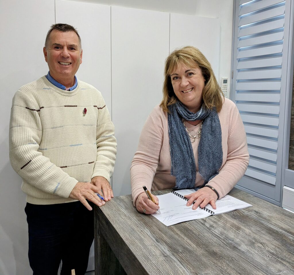 Heather Nogueria, signs franchise agreement with Chris Rocker, founder of Just Shutters